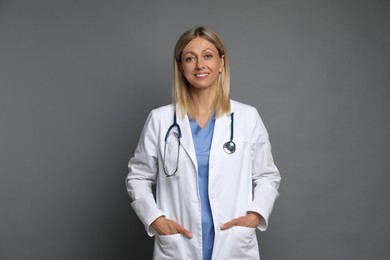 Photo of Portrait of doctor in medical uniform with stethoscope on grey background