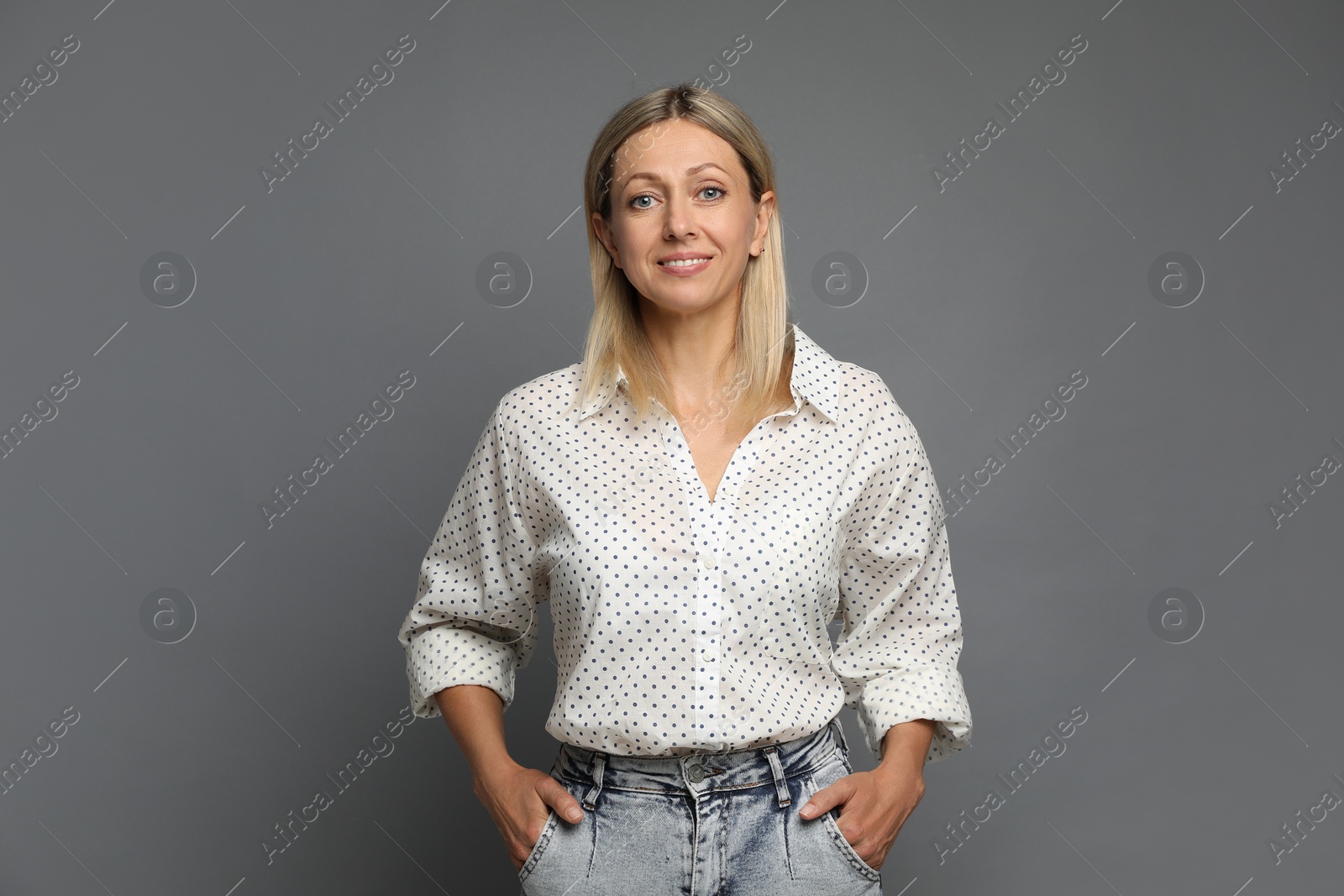 Photo of Portrait of beautiful smiling woman on grey background