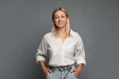 Photo of Portrait of beautiful smiling woman on grey background