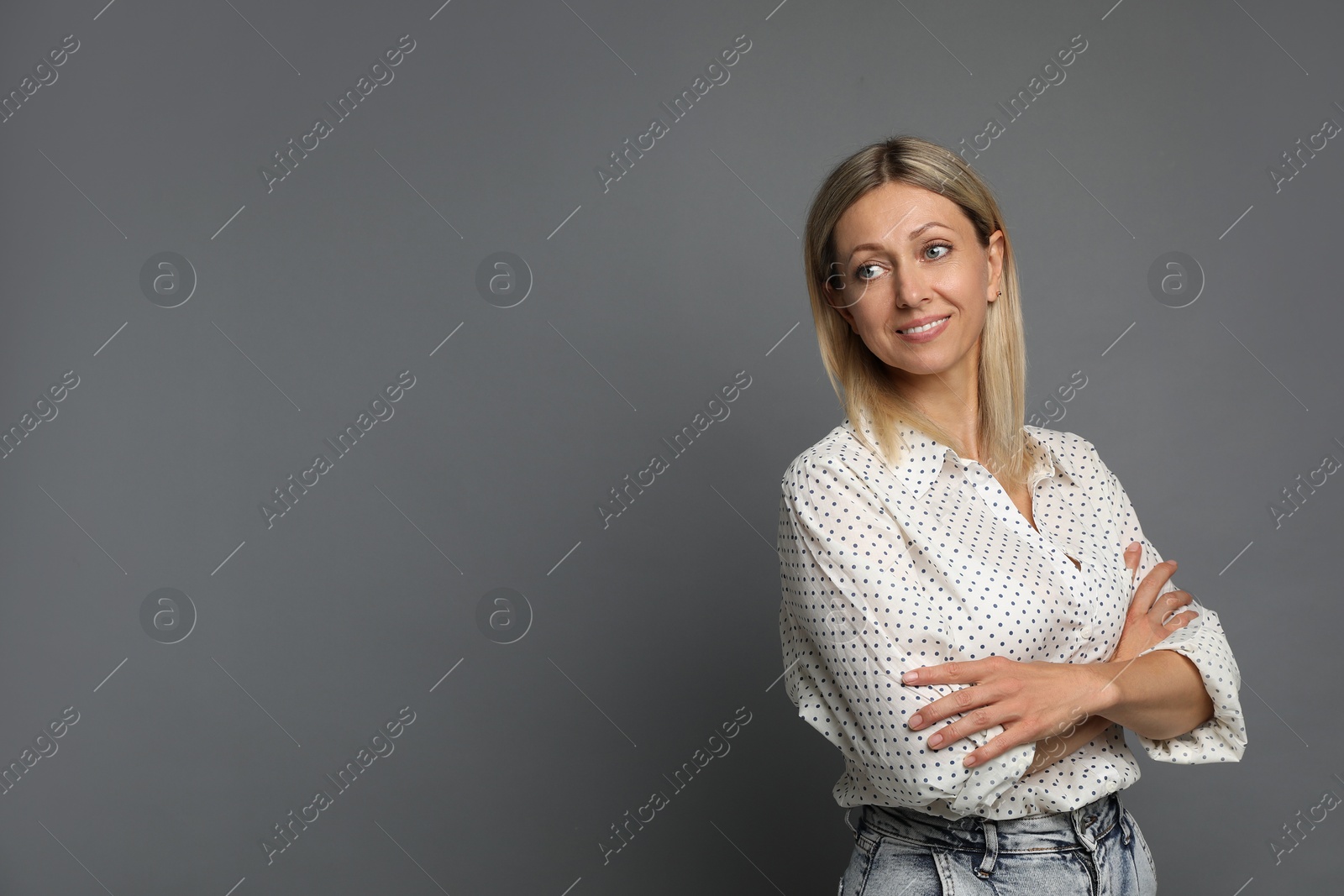 Photo of Portrait of beautiful smiling woman on grey background, space for text