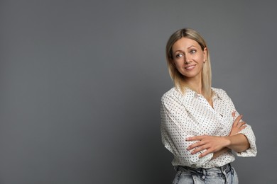 Portrait of beautiful smiling woman on grey background, space for text