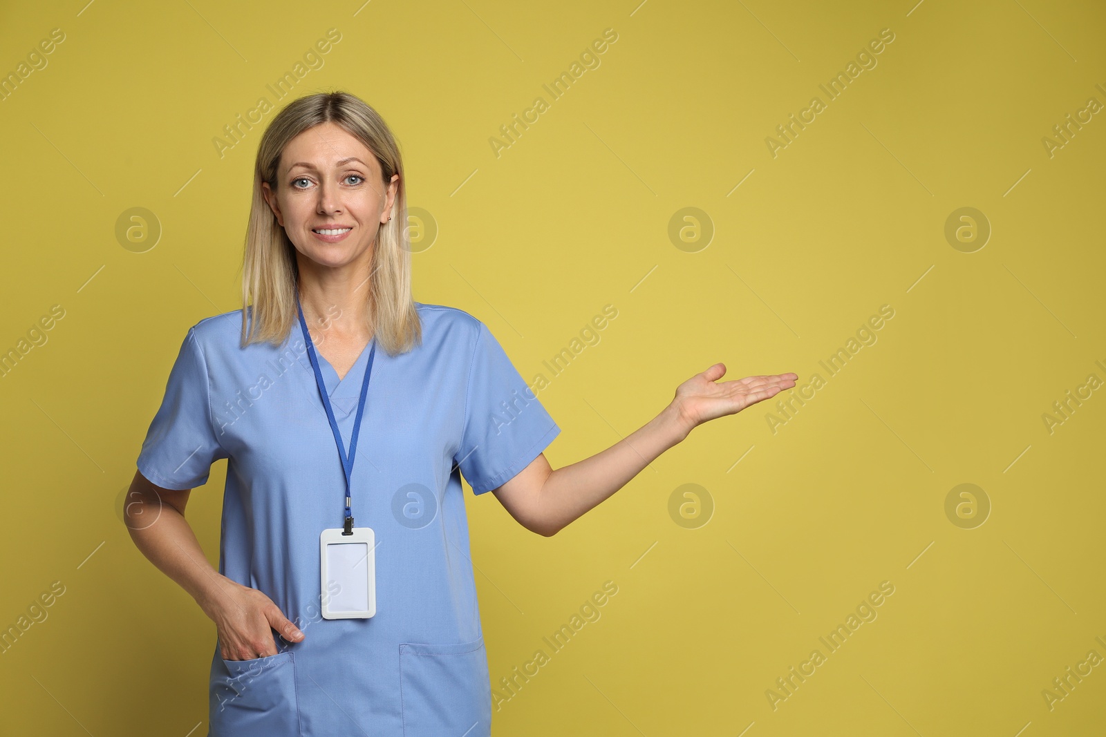 Photo of Portrait of nurse in medical uniform with badge on yellow background, space for text