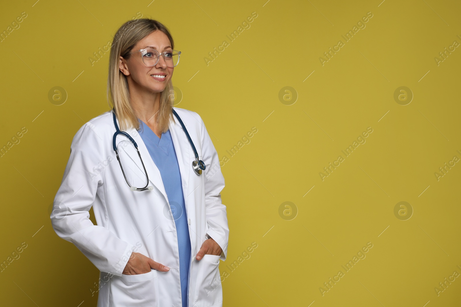 Photo of Portrait of doctor in medical uniform with stethoscope on yellow background, space for text