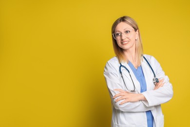 Photo of Portrait of doctor in medical uniform with stethoscope on yellow background, space for text