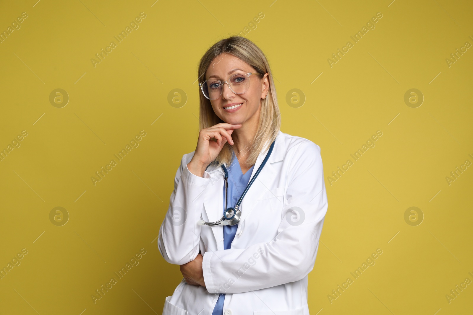 Photo of Portrait of doctor in medical uniform with stethoscope on yellow background