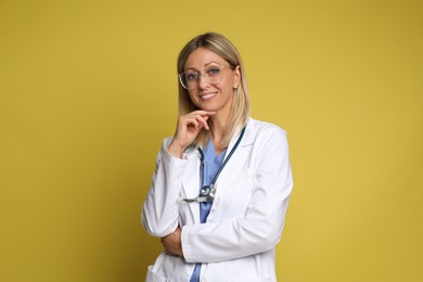 Portrait of doctor in medical uniform with stethoscope on yellow background