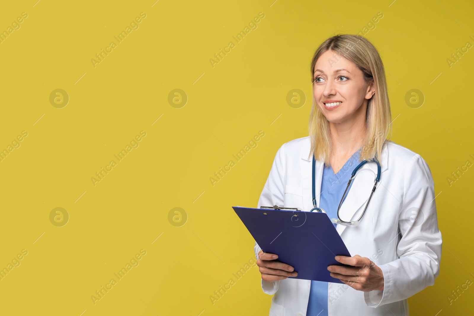 Photo of Doctor in medical uniform with stethoscope and clipboard on yellow background, space for text