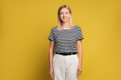 Photo of Portrait of beautiful smiling woman on yellow background