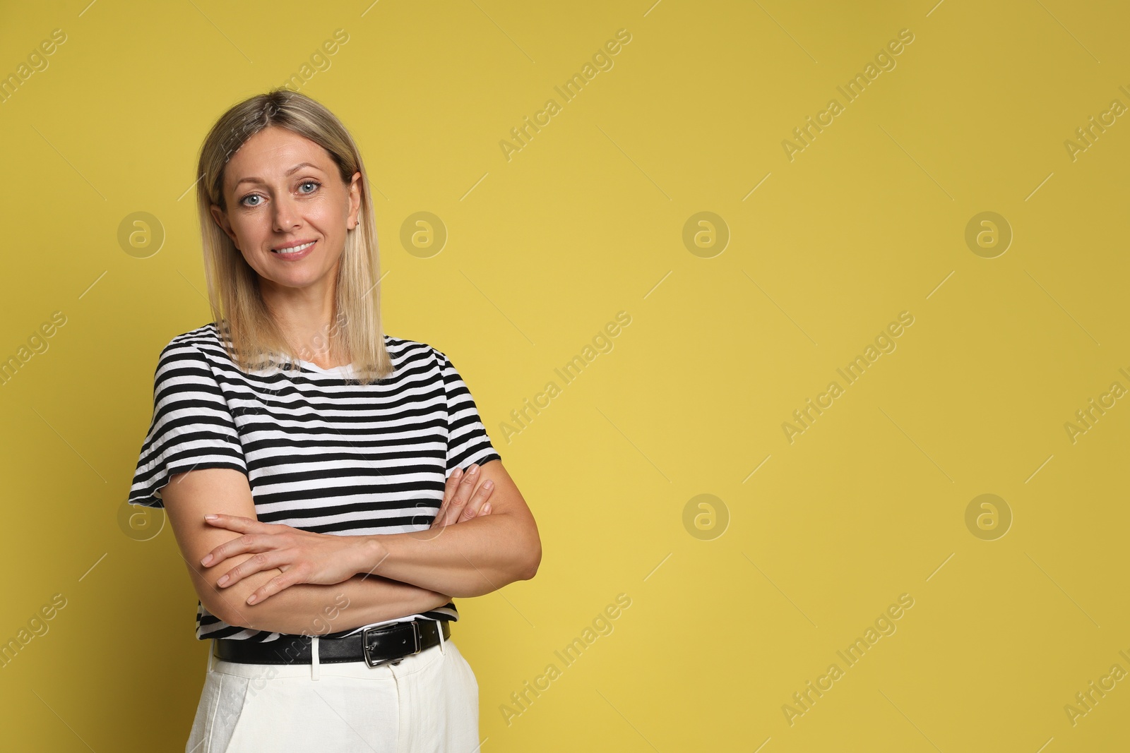 Photo of Portrait of beautiful smiling woman on yellow background, space for text