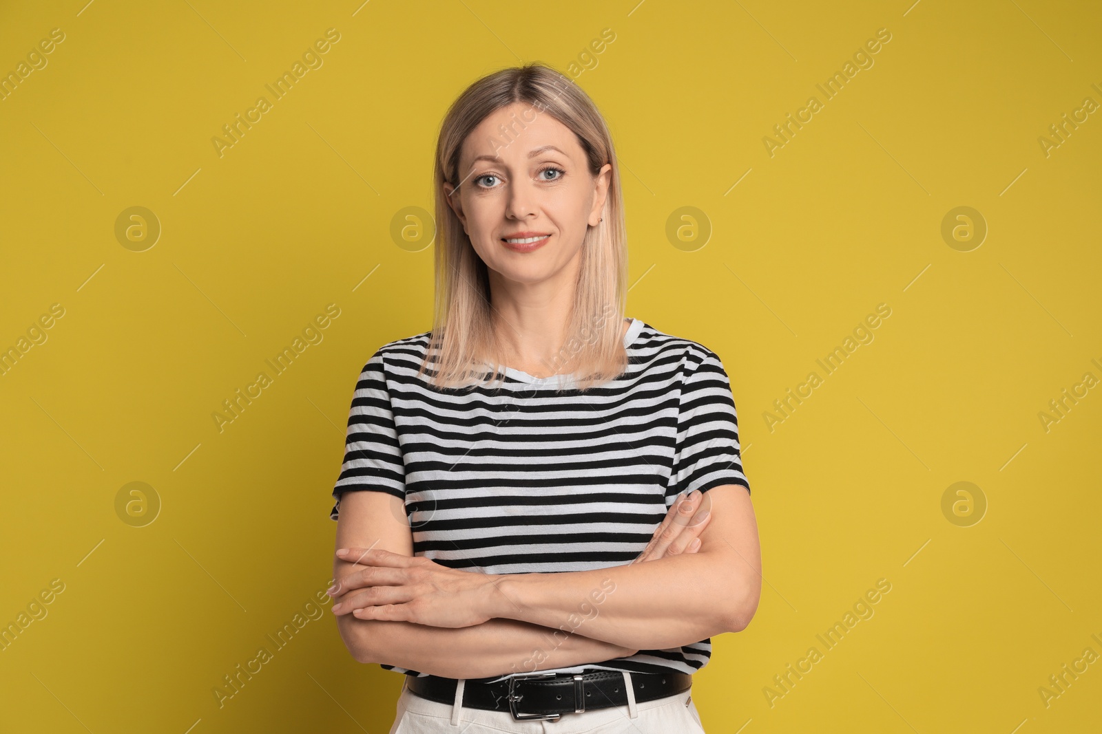 Photo of Portrait of beautiful smiling woman on yellow background