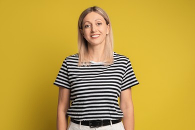 Photo of Portrait of beautiful smiling woman on yellow background