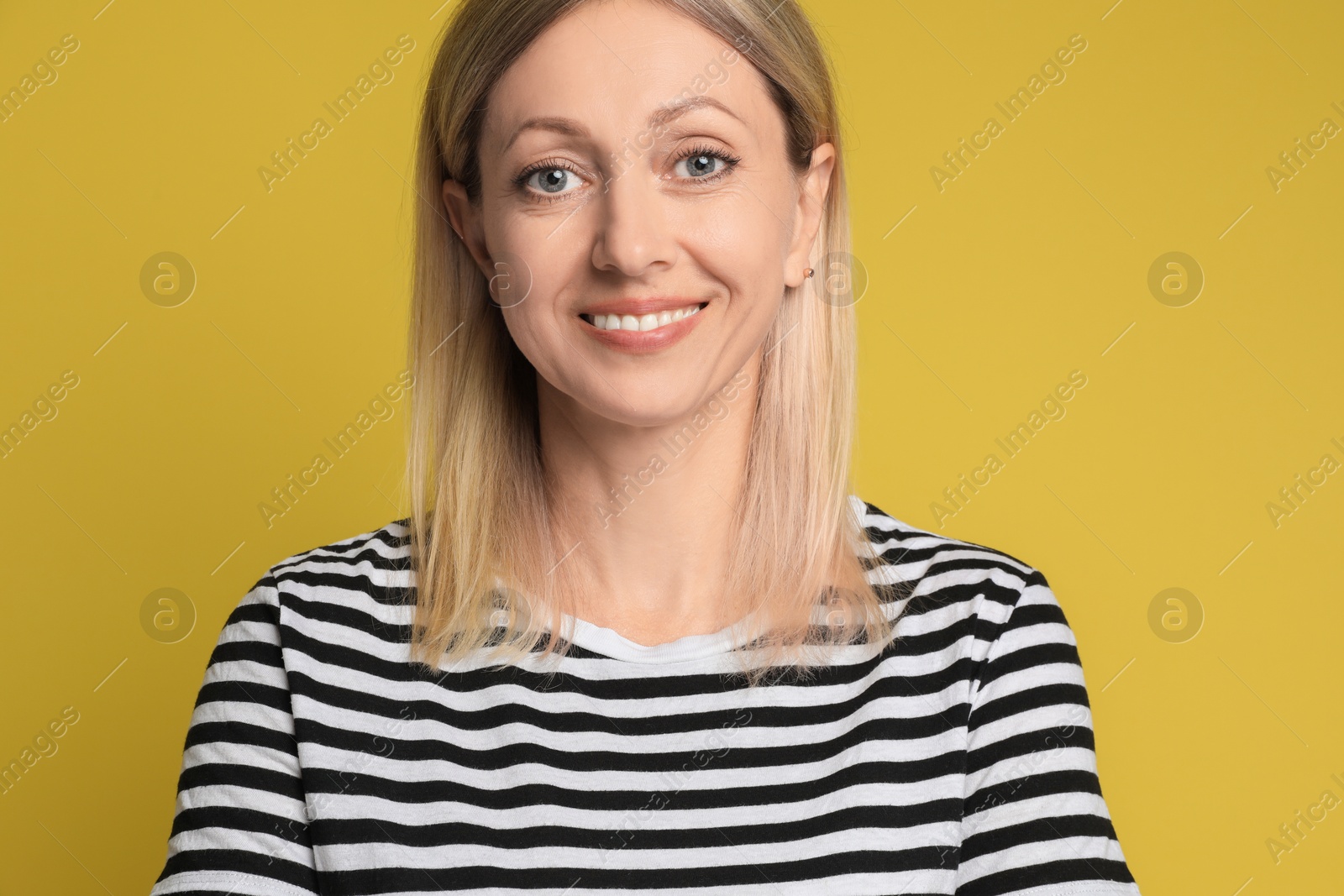 Photo of Portrait of beautiful smiling woman on yellow background