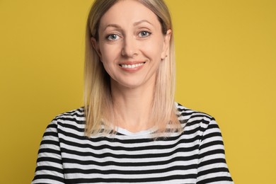 Photo of Portrait of beautiful smiling woman on yellow background