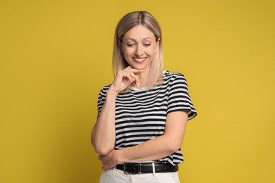 Photo of Portrait of beautiful smiling woman on yellow background