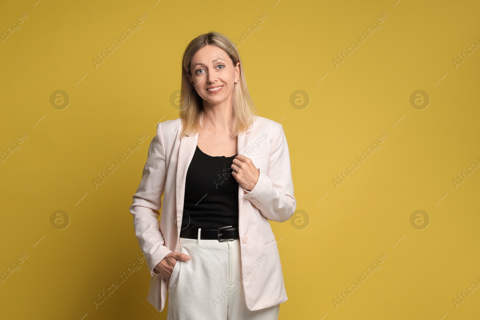 Photo of Portrait of beautiful smiling woman on yellow background