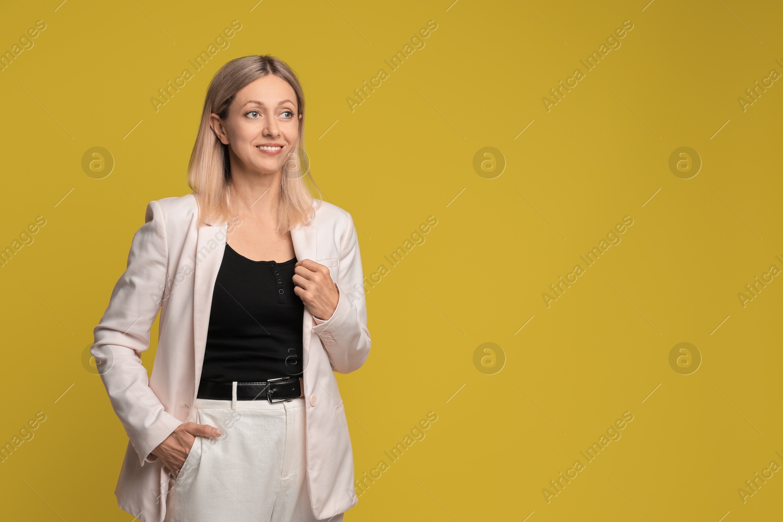 Photo of Portrait of beautiful smiling woman on yellow background, space for text