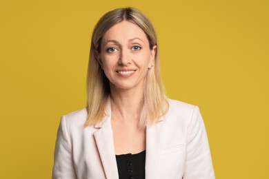 Portrait of beautiful smiling woman on yellow background