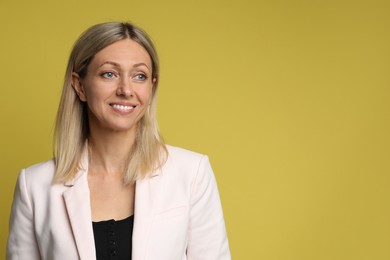 Portrait of beautiful smiling woman on yellow background, space for text