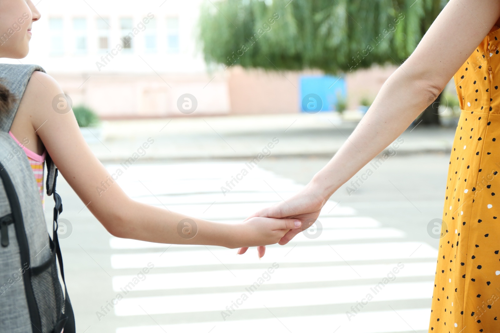 Photo of Mother and daughter holding hands outdoors, closeup