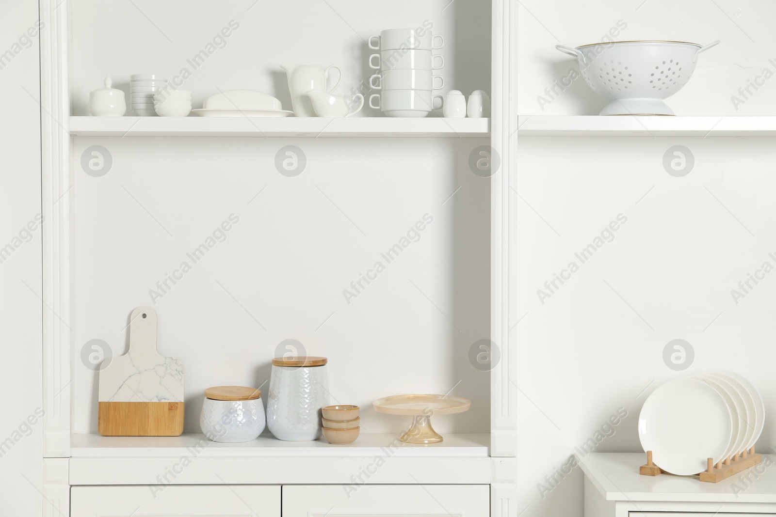 Photo of White shelving unit with different kitchenware indoors