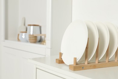 Photo of White shelving unit with different kitchenware indoors