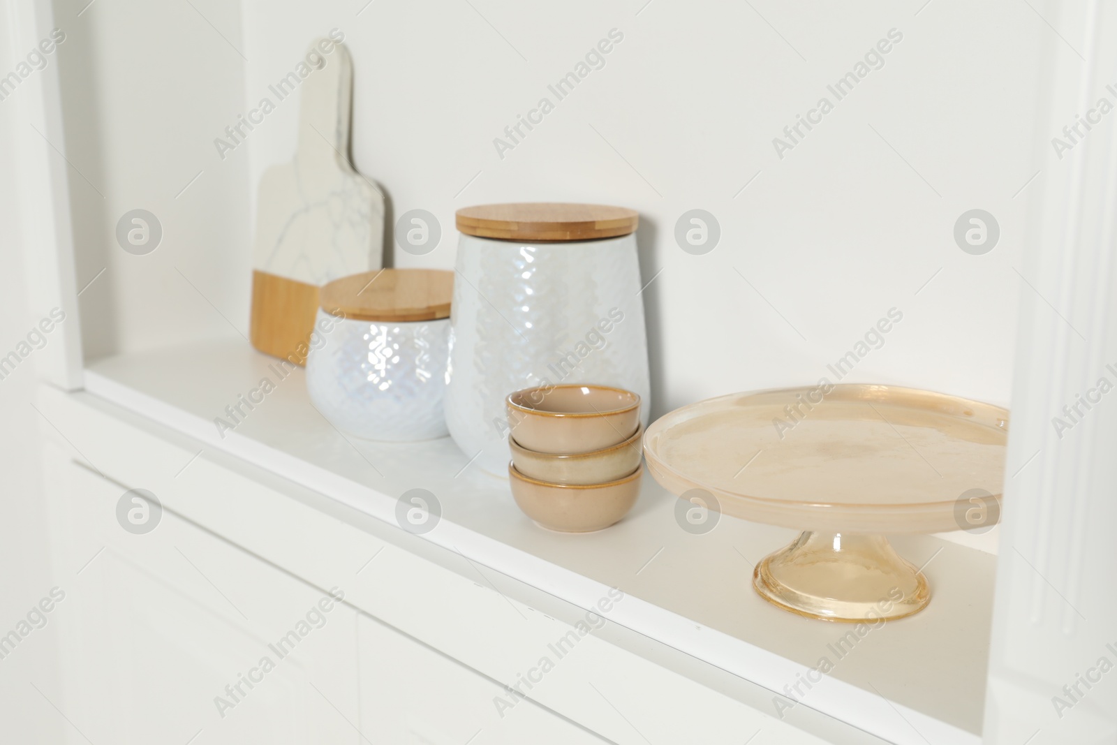 Photo of White shelving unit with different kitchenware indoors