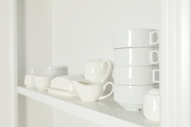 White shelving unit with dishware indoors, closeup