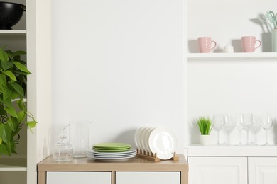 Shelving unit with different kitchenware near white wall indoors