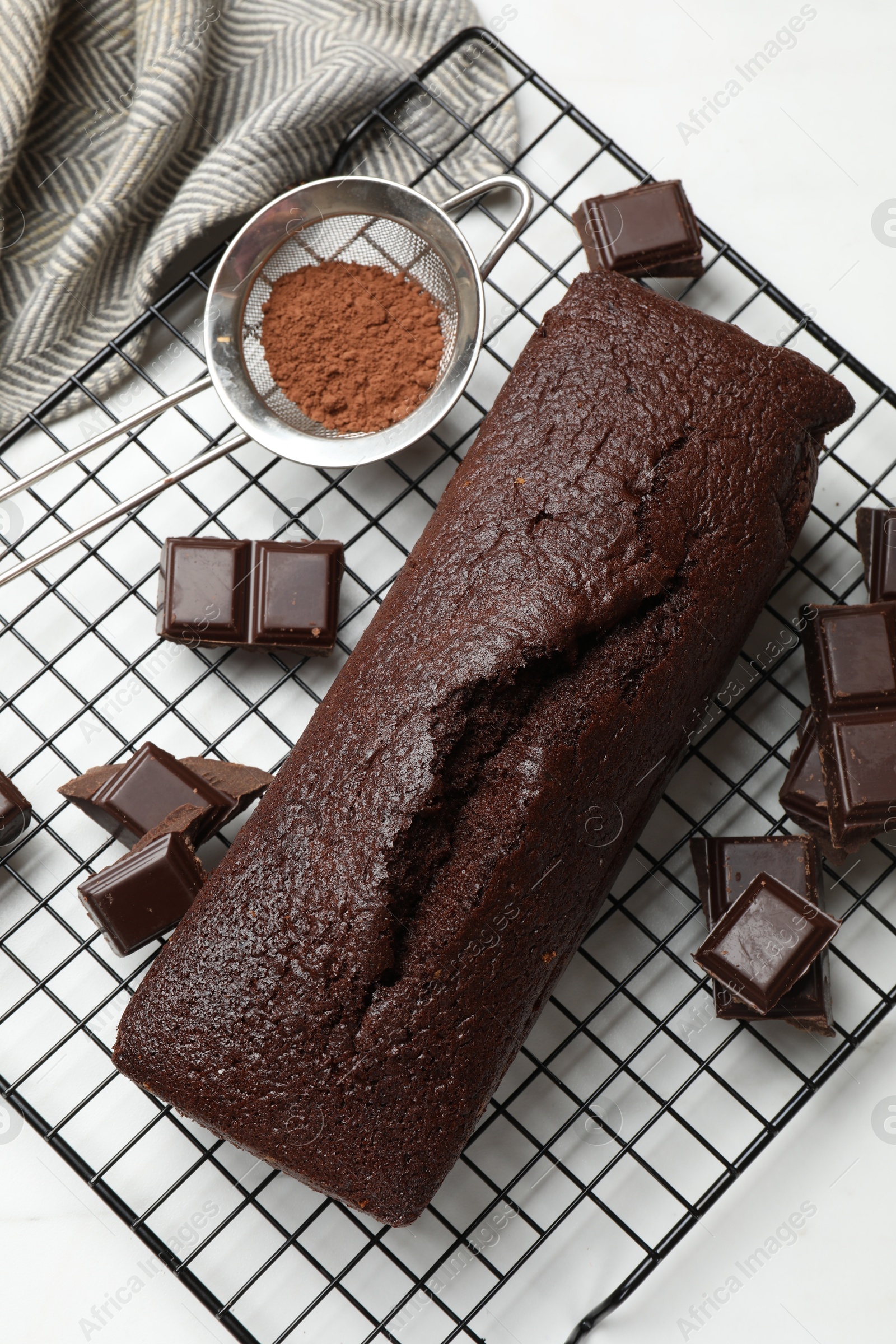 Tasty chocolate sponge cake and ingredients on white marble table, flat lay Photo of Tasty chocolate sponge cake and ingredients on white marble table, flat lay