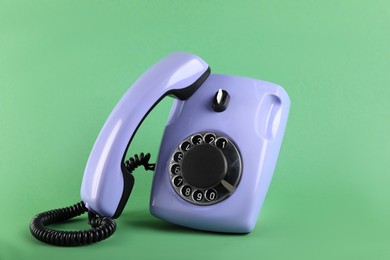 Photo of One violet telephone with handset on green background