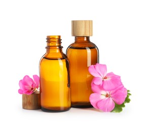 Photo of Geranium essential oil in bottles and beautiful flowers isolated on white