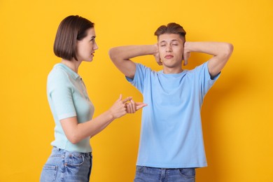 Photo of Emotional young couple arguing on orange background