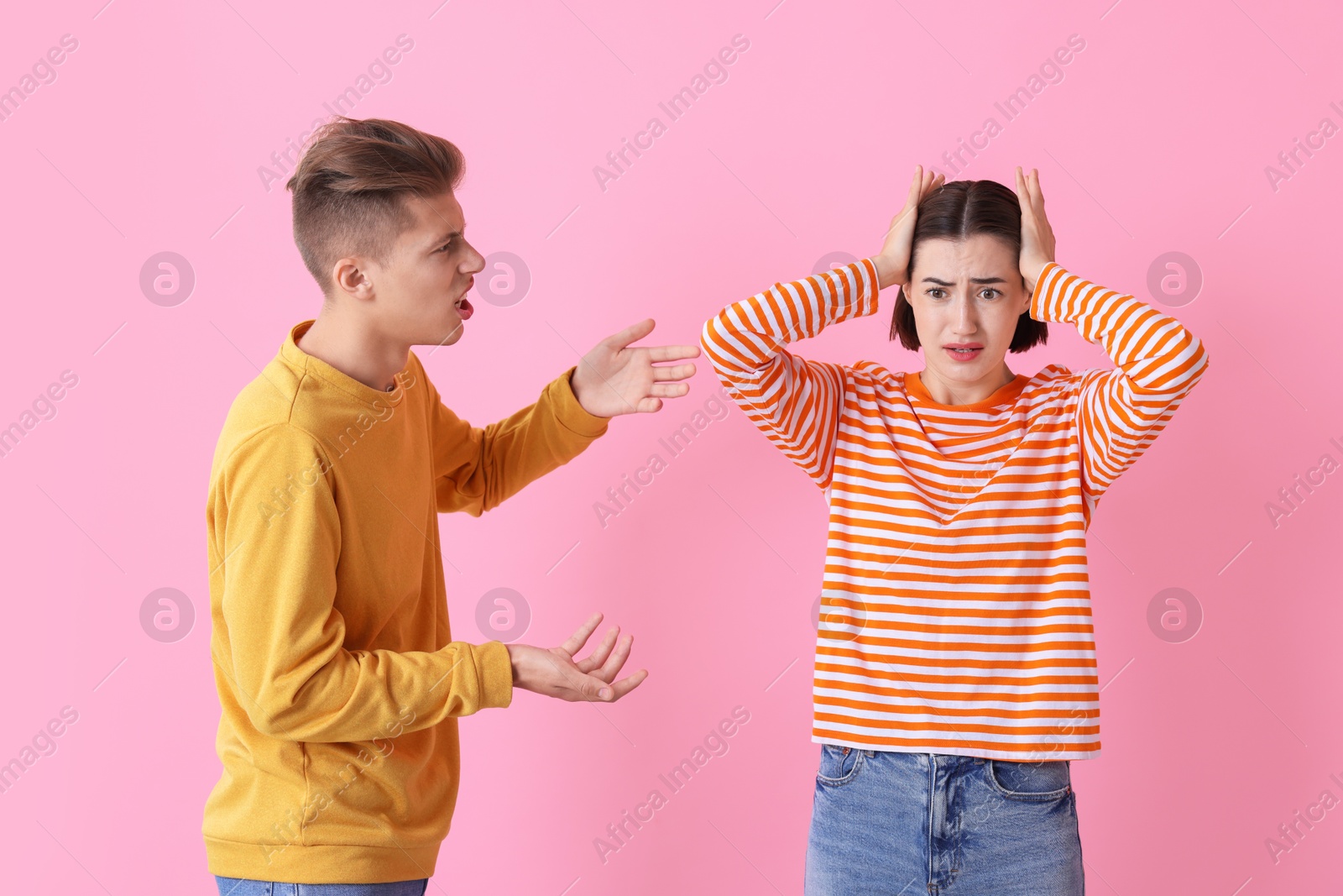 Photo of Emotional young couple arguing on pink background