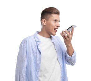 Young man recording voice message via smartphone on white background