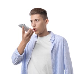 Young man recording voice message via smartphone on white background