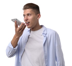 Young man recording voice message via smartphone on white background