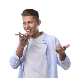 Young man recording voice message via smartphone on white background