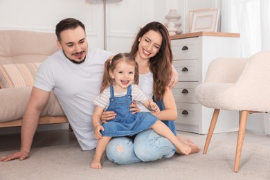 Happy family. Parents and their cute little daughter at home