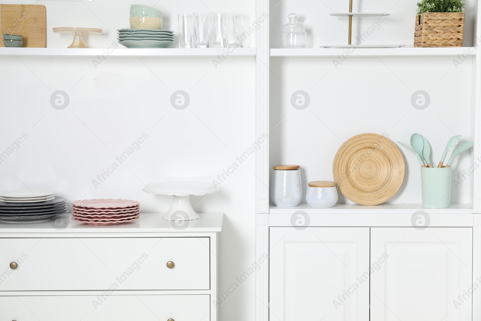 Photo of White shelving unit with different kitchenware indoors