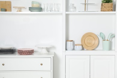 Photo of White shelving unit with different kitchenware indoors