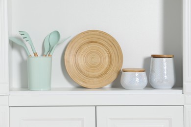 Photo of White shelving unit with different kitchenware indoors