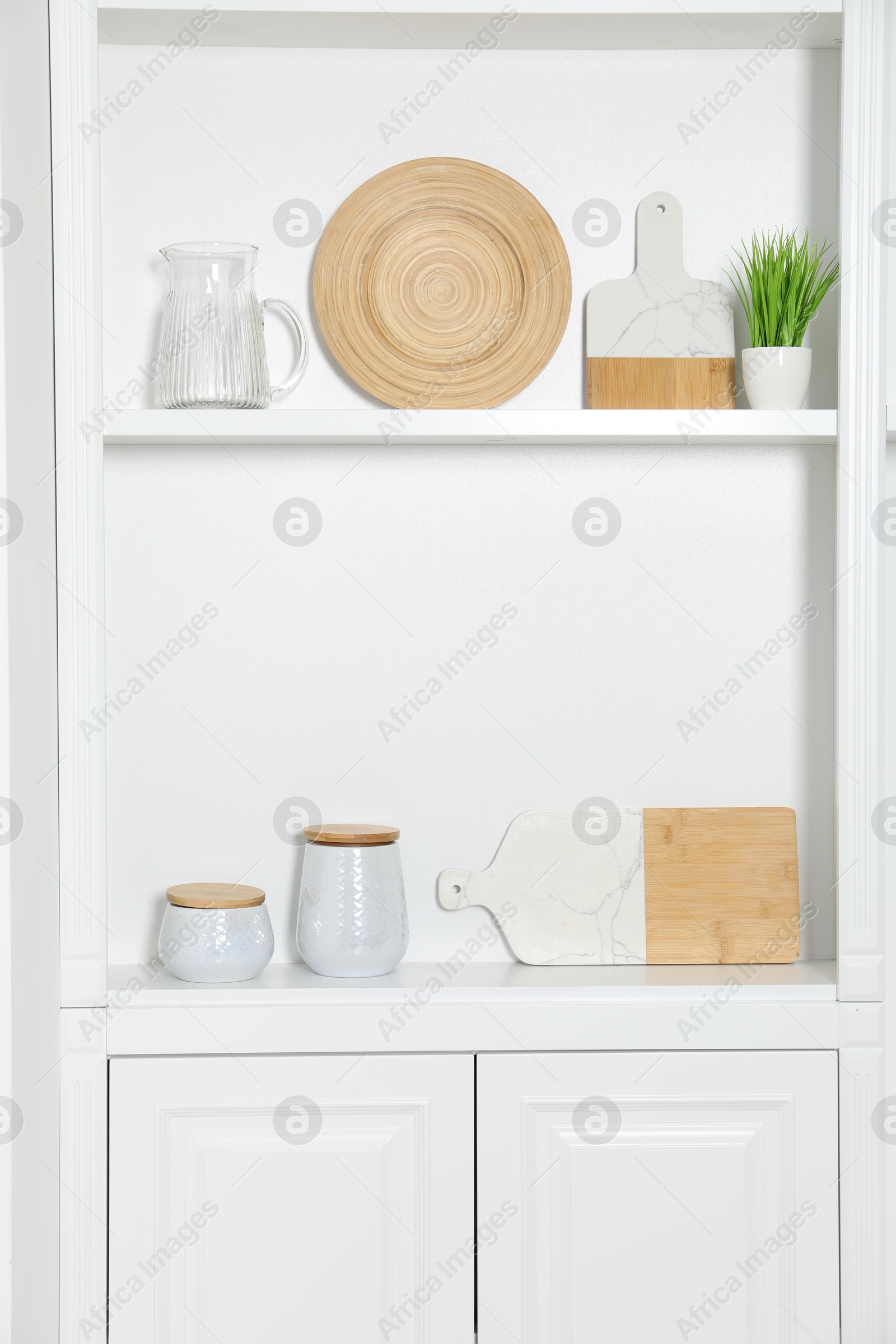 Photo of White shelving unit with different kitchenware indoors