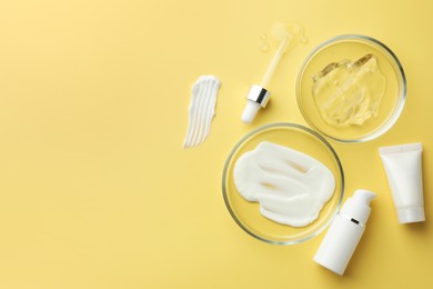 Photo of Petri dishes with cosmetic products and pipette on yellow background, flat lay. Space for text