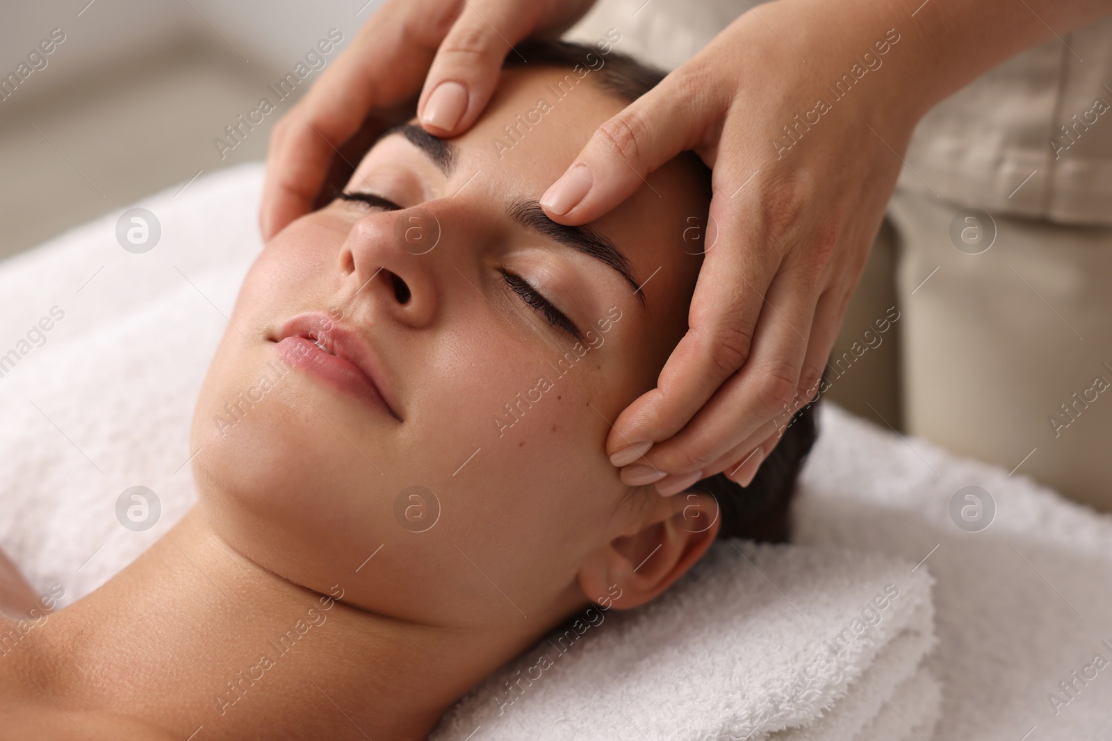 Photo of Attractive woman enjoying face massage, closeup. Beauty procedure