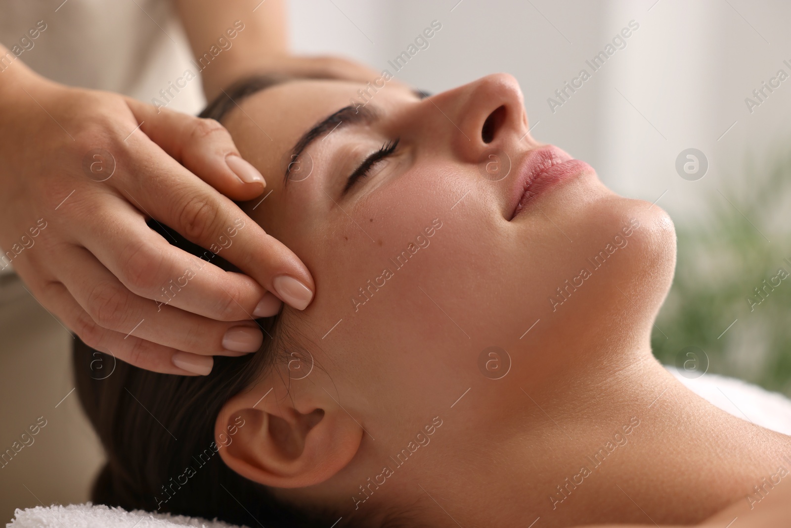 Photo of Attractive woman enjoying face massage, closeup. Beauty procedure