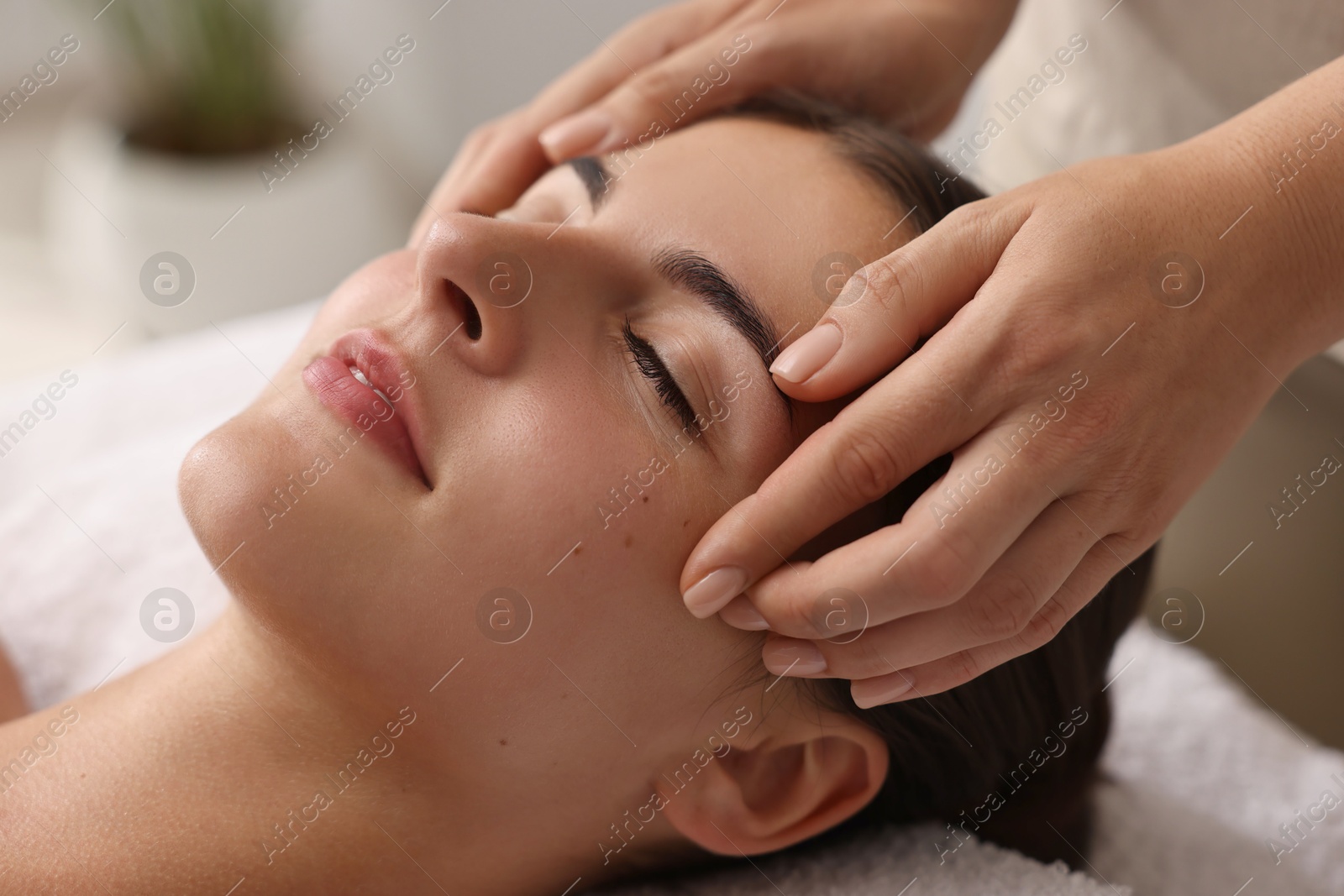 Photo of Attractive woman enjoying face massage, closeup. Beauty procedure