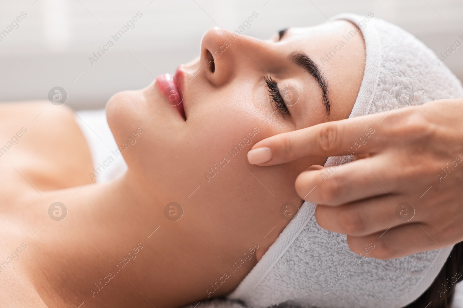 Photo of Attractive woman enjoying face massage, closeup. Beauty procedure