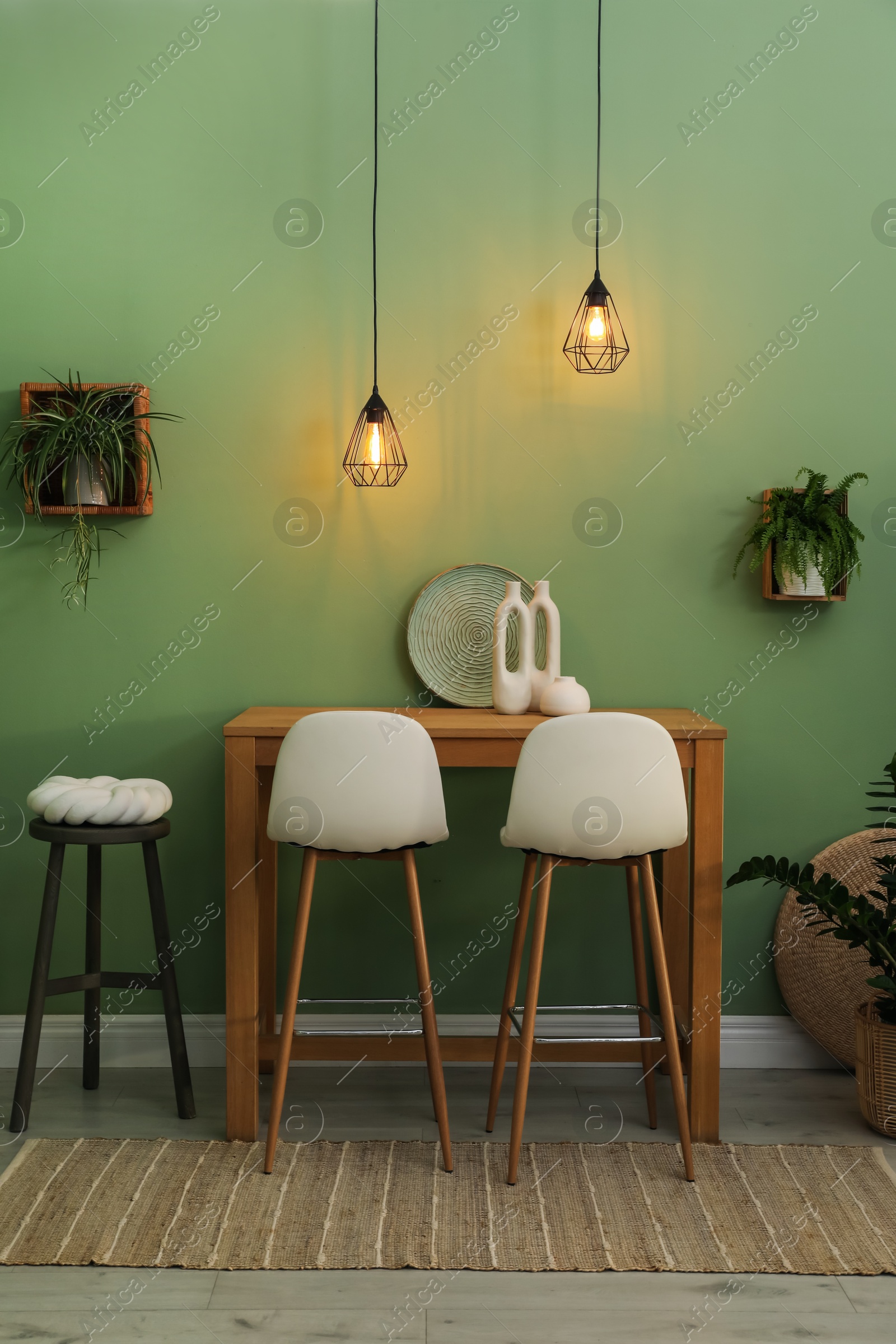 Photo of Bar stools, table and plants in room. Stylish interior design