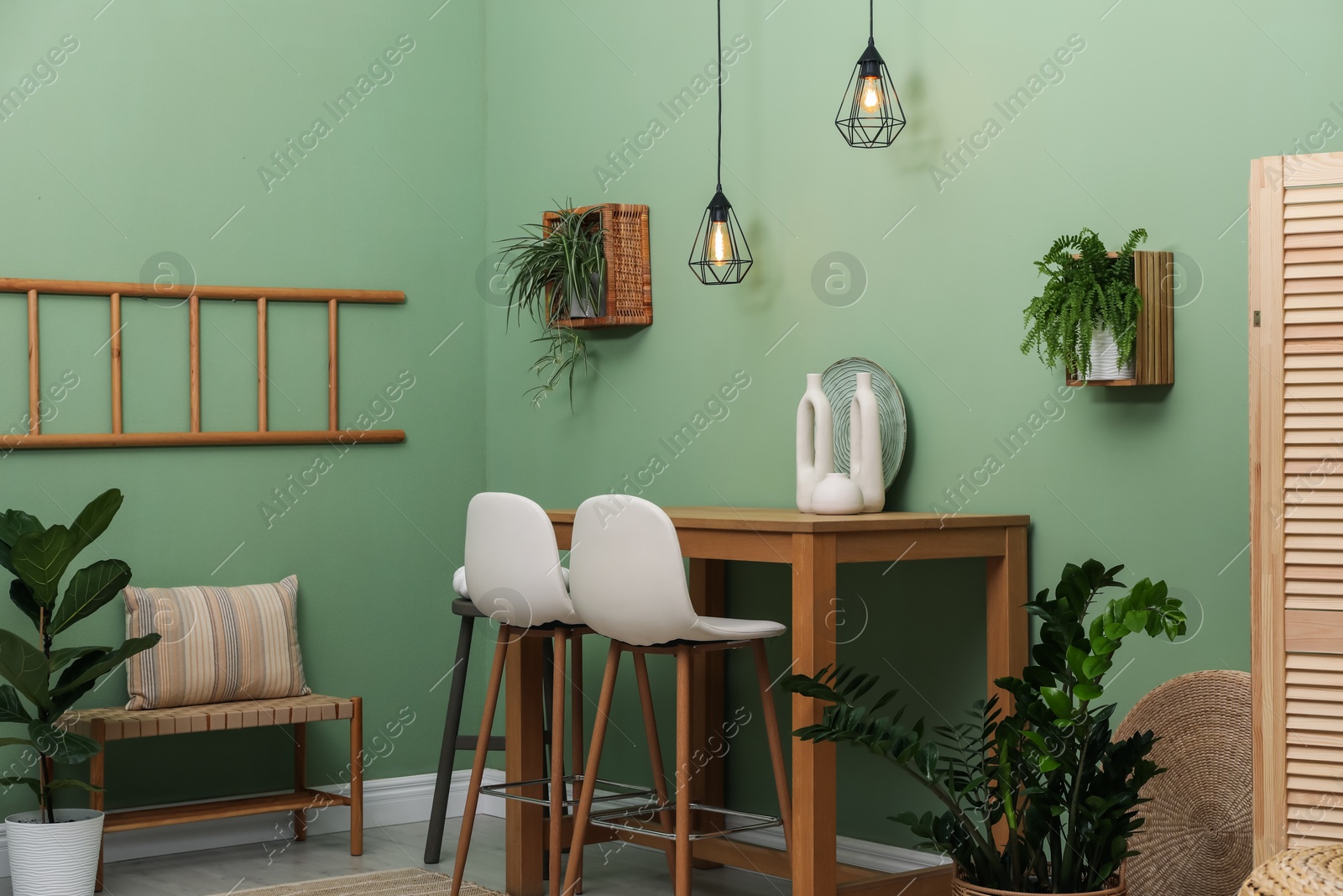 Photo of Bar stools, table and plants in room. Stylish interior design