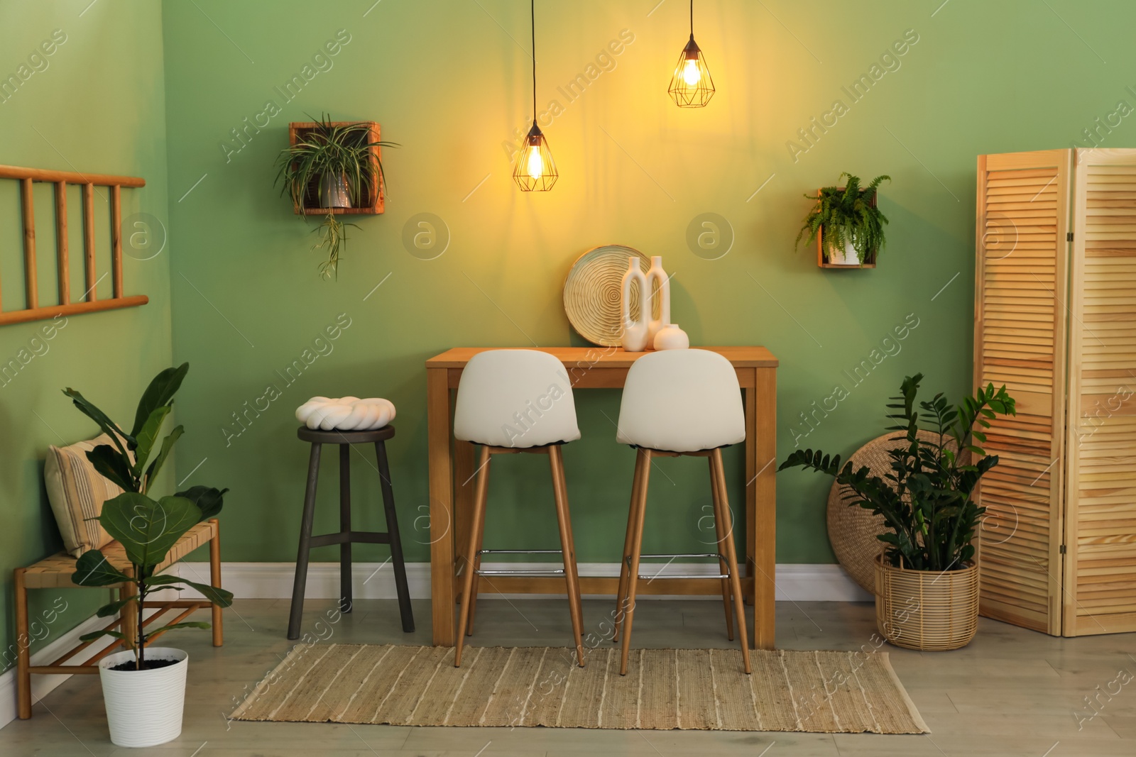 Photo of Bar stools, table and plants in room. Stylish interior design